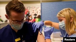 Una estudiante de medicina administra una vacuna contra el COVID-19 en la Indiana University Health Methodist Hospital en Indianápolis, el 16 de diciembre de 2020.