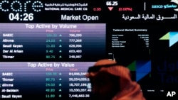 FILE - A Saudi man looks at stocks at the Tadawul Saudi Stock Exchange, in Riyadh, Saudi Arabia, June 15, 2015. Saudi Arabia's stock market was opened up to foreign direct investment for the first time in mid-2015 as the kingdom sought an economic boost amid low oil prices.