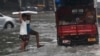 Indian boys navigate their way through a waterlogged street in Mumbai, India, Sept. 20, 2017.