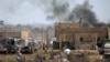 Islamic State members walk in the last besieged neighborhood in the village of Baghouz, Deir al-Zor province, Syria, March 10, 2019. 