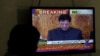 A man looks at a television screen displaying cricketer-turned-politician Imran Khan being sworn in as prime minister of Pakistan, in Karachi, Pakistan, Aug. 18, 2018.