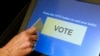 FILE - An elections official demonstrates a touch-screen voting machine at the Fairfax County Governmental Center in Fairfax, Virginia.