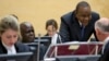 FILE - Kenya President Uhuru Kenyatta, second right, talks to his defense team when appearing before the International Criminal Court (ICC) in The Hague, Netherlands, Oct. 8, 2014.