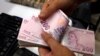 FILE - A money changer counts Turkish lira banknotes at a currency exchange office in Istanbul, Turkey, Aug. 2, 2018. 