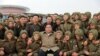 This undated picture released from North Korea's official Korean Central News Agency, Nov. 18, 2019, shows North Korean leader Kim Jong Un posing with members of the Air and Anti-Aircraft Force of the Korean People's Army.
