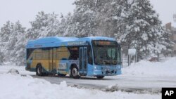 Un autobús de la Autoridad Intergubernamental de Transporte Público del norte de Arizona (NAIPTA por sus siglas en inglés) se dirige entre la nieve al centro de Flagstaff, Arizona, el viernes 29 de noviembre de 2019. (Cody Bashore/Arizona Daily Sun vía AP).