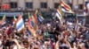 ໃນ​ພາບນີ້​ທີ່​ຖືກ​ເຜີຍ​ແຜ່​ໂດຍ Suwayda24, ສະ​ແດງ​ໃຫ້​ເຫັນ​ປະ​ຊາ​ຊົນ​ຈັດ​ການ​ປະ​ທ້ວງ ໃນ​ຂະ​ນະ​ທີ່​ເຂົາ​ເຈົ້າ​ຍົກ​ທຸງ ດ​ຣູ​ສ໌ ໃນ​ເມືອງ ສ​ເວ​ດາ, ປະ​ເທດ ຊີ​ເຣຍ, 1 ກັນ​ຍາ 2023.