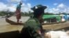 A Myanmar soldier patrols in a boat at the Mayu river while boats deliver food to isolated communities near Buthidaung in the north of Rakhine state, Sept. 13, 2017. 