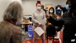 Ljudi stoje u redu da dobiju dopunsku dozu Pfizer vakcine protiv COVID-19 u mobilnoj klinici za vakcinaciju u Worcesteru, Massachusetts, 2. decembra 2021.
