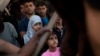Migrants and refugees wait to leave the Golfo Azzurro rescue vessel as they arrive at the port of Pozzallo, south of Sicily, Italy, with hundreds of migrants aboard, rescued by members of Proactive Open Arms NGO, June 17, 2017.