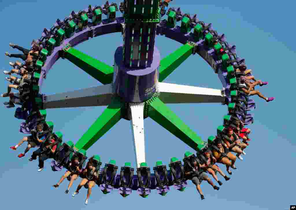 Los visitantes de Six Flag Fiesta Texas usan máscaras para protegerse contra el COVID-19 en San Antonio. El parque temático reabrió el viernes mientras los casos de COVID-19 continúan aumentando en Texas.