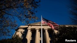 ARCHIVO - Una bandera estadounidense ondea frente al edificio del Departamento de Justicia en Washington, Estados Unidos, en diciembre de 2020.
