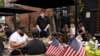 As Phase One of reopening begins in Northern Virginia, a waiter in a face mask to protect against the coronavirus (COVID-19) serves diners seated outdoors at a restaurant in Alexandria, Virginia, U.S., May 29, 2020. 