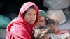 A woman looks as she sits with her children at a camp for internally displaced people on the outskirts of Sanaa, Yemen, March 1, 2021. 