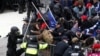 Los manifestantes pro-Trump derriban una barricada mientras chocan con la policía del Capitolio durante un mitin para impugnar la certificación de los resultados de las elecciones presidenciales de los EE. UU. 2020 por parte del Congreso de los EE. UU.