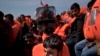 Migrants are rescued from a rubber boat by members of Proactiva Open Arms NGO, in the Mediterranean sea, about 56 miles north of Sabratha, Libya, April 6, 2017. With the Greek smuggling route largely closed off, the path of least resistance drifted to Libya _ a sprawling lawless country with a huge coast and competing rebel and government factions. Migrants have flooded into Libya from across Africa, producing a bonanza for smugglers. 