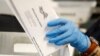FILE - A worker processes mail-in ballots at the Bucks County Board of Elections office prior to a primary election, in Doylestown, Pennsylvania, May 27, 2020. Nevada has just adopted mail-in voting for the November general election.