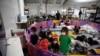 Menores migrantes no acompañados, de 3 a 9 años, ven TV en la instalación de Aduanas y Protección Fronteriza de EE. UU., en Donna, Texas, el 30 de marzo de 2021.