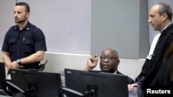 FILE - Former Ivory Coast President Laurent Gbagbo, center, and his lawyer Emmanuel Altit, right, wait for the start of the trial at the International Criminal Court in The Hague, Netherlands, Jan. 28, 2016. 