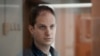 ARCHIVO-El reportero del Wall Street Journal, Evan Gershkovich, en una celda con cobertura de vidrio en una sala del Tribunal Municipal de Moscú, Rusia, en una foto del 10 de octubre de 2023. Un juez decidió extender por dos meses más su detención.