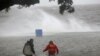 Two men walk in the storm surge from Hurricane Isaac on Lakeshore Drive along Lake Pontchartrain, as the storm approaches New Orleans, Aug. 28, 2012.