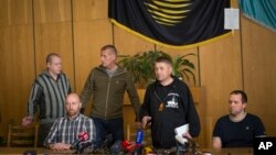 El líder separatista Vacheslav Ponomarev, (segundo de la derecha) aparece con los rehenes europeos en la alcaldía de Slovyansk, en Ucrania.
