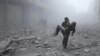 A wounded man is carried following an air strike on the rebel-held besieged town of Arbin, in the eastern Ghouta region on the outskirts of the capital Damascus on January 2, 2018.