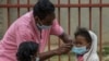 Face masks are placed on children in Antananarivo, Madagascar, Oct. 3, 2017. Authorities in Madagascar are struggling to contain an outbreak of plague that has killed at least 20 people, and the government has begun a campaign to disinfect school classroo