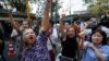 Voters hold their identification cards and the chains that held the gate of the polling station closed, as they demand the right to vote during general elections in Bangkok, Thailand, Feb. 2, 2014.