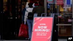 ARCHIVO - Se muestra un cartel de contratación afuera de una tienda minorista en Vernon Hills, Illinois, el 13 de noviembre de 2021.