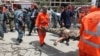 An Afghan municipality worker carries the body of a Taliban after clashes in front of the Parliament, in Kabul, Afghanistan, June 22, 2015. 