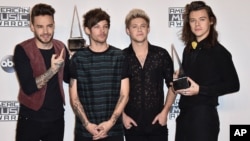 Liam Payne, from left, Louis Tomlinson, Niall Horan and Harry Styles of One Direction pose in the press room with the award for artist of the year at the American Music Awards at the Microsoft Theater on Nov. 22, 2015, in Los Angeles.