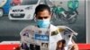 A man wearing a face mask reads a newspaper with the front page headline reporting on Joe Biden's projected U.S. presidential election victory, in Manama, Bahrain, Nov. 8, 2020.