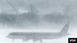 En el aeropuerto de Filadelfia un avión de U.S. Airways aguarda en medio de la nevisca. Muchos pasajeros debieron esperar dentro de los aviones.