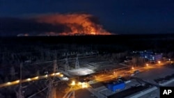 In this photo taken from the roof of Ukraine's Chernobyl nuclear power plant late Friday April 10, 2020, a forest fire is seen burning near the plant inside the exclusion zone. Ukrainian firefighters are labouring to put out two forest blazes in…