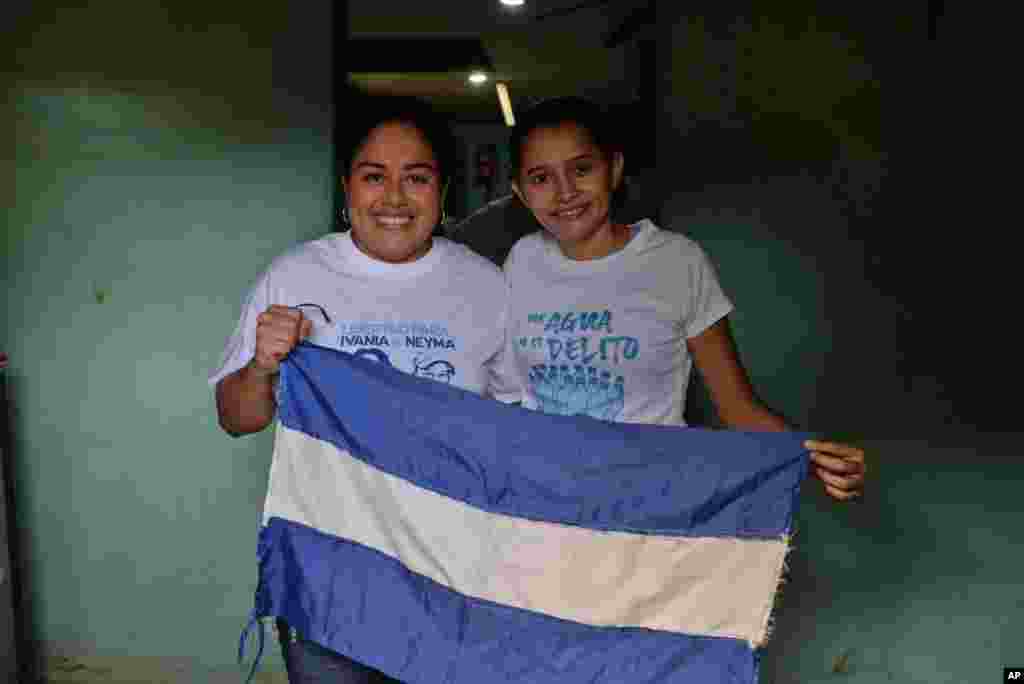 Ivania Álvarez, a la izquierda, y Neyma Hernández, posan para un retrato con una bandera nicaragüense mientras celebran su liberación en la casa de Álvarez en Managua, Nicaragua, el lunes 30 de diciembre de 2019. Ambas pertenecían a los conocidos como &quot;aguadores&quot;, en alusión al grupo de personas que llevó agua a manifestantes en una iglesia. Las protestas contra el gobierno de Daniel Ortega comenzaron en abril de 2018 por una revisión de la política de seguridad social, que se amplió para incluir otras demandas como la salida de Ortega del cargo y elecciones anticipadas. (Foto de AP)