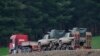 A truck, part of a convoy, carrying military pickup trucks with machine guns attached is seen on the outskirts of the village of Sugedigi, Turkey, Jan. 21, 2018. 