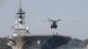 FILE - A helicopter lands on the Izumo, Japan Maritime Self Defense Force's (JMSDF) helicopter carrier, at JMSDF Yokosuka base in Yokosuka, south of Tokyo, Japan, Dec. 6, 2016. 