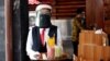 A waiter wearing a face shield and a protective face mask carries a tray with drinks as she serves customers in a Bumi Aki restaurant amid the coronavirus disease (COVID-19) outbreak in Bogor, near Jakarta, Indonesia, May 29, 2020. 