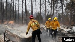 Bomberos remueven escombros mientras recuperan restos humanos de una casa rodante destruida por el incendio Camp, en Paradise, California. Noviembre 17 de 2018.