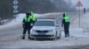 Traffic police officers stand guard on a road near the crash site of the Russian Ilyushin Il-76 military transport plane outside the village of Yablonovo in the Belgorod Region, Russia Jan. 24, 2024. 