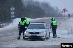 Polisi lalu lintas berjaga di jalan dekat lokasi jatuhnya pesawat angkut militer Ilyushin Il-76 Rusia di luar desa Yablonovo, wilayah Belgorod, Rusia, 24 Januari 2024. (REUTERS/Stringer)