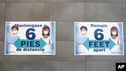 Carteles en una pared les recuerdan a estudiantes mantener una distancia de 6 pies (2 metros ) entre sí en la Escuela Secundaria Norris en Omaha, Nebraska, el 29 de julio del 2020. Foto AP.