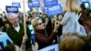 Democratic presidential candidate Sen. Elizabeth Warren, D-Mass., greets a young supporter as she walks from her home with husband Bruce Mann, left, to the nearby polling location to vote on March 3, 2020, in Cambridge, Mass.
