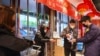 Un empleado distribuye desinfectante a clientes a la entrada de un supermercado en Wuhan, en la provincia de Hubei, en el centro de China, el sábado 25 de enero de 2020, debido a una epidemia de un mortal virus que afecta las vías respiratorias. (Chinatopix vía AP)