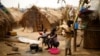 FILE - Families living in a refugee camp prepare food in Kaga-Bandoro, Central African Republic, Tuesday Feb. 16, 2016. 