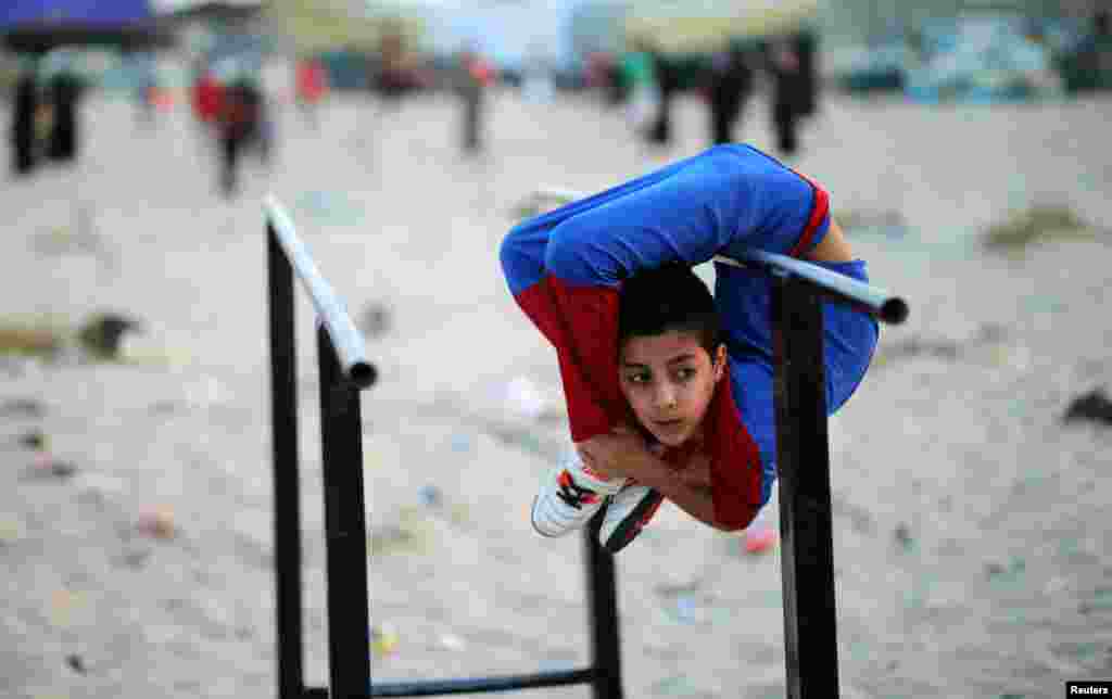 Seorang anak Palestina, Mohamad al-Sheikh (12 tahun), yang dijuluki &#39;Spiderman&#39;, menunjukkan kemampuan akrobatiknya di sebuah pantai di Gaza City.
