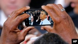 Uno de los asistentes al discurso del presidente Barack Obama en Phoenix, capta una imagen del mandatario tras el evento.