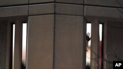 Un prisionero muestra su mano por una ventana de la prisión del condado de Pierce, en el estado de Washington, mientras frente a la cárcel pasaba una marcha contra el maltrato policial en Estados Unidos. 