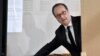 FILE - French president Francois Hollande picks up ballots before voting in the first round of the presidential election in Tulle, central France, Apr. 23, 2017. 